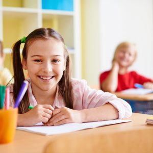 Portrait of lovely girl looking at camera at lesson of drawing