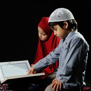 Muslim kids reading holy koran on  black background